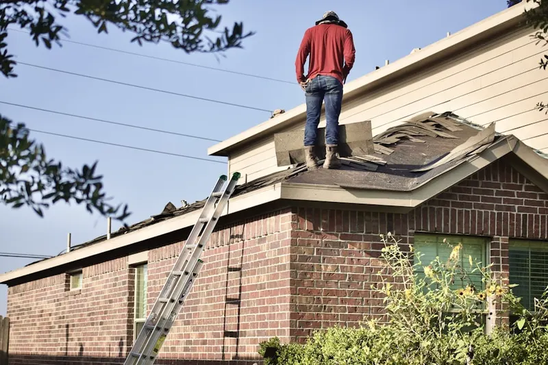 Professional roofer working on a residential roof in Charles Village
